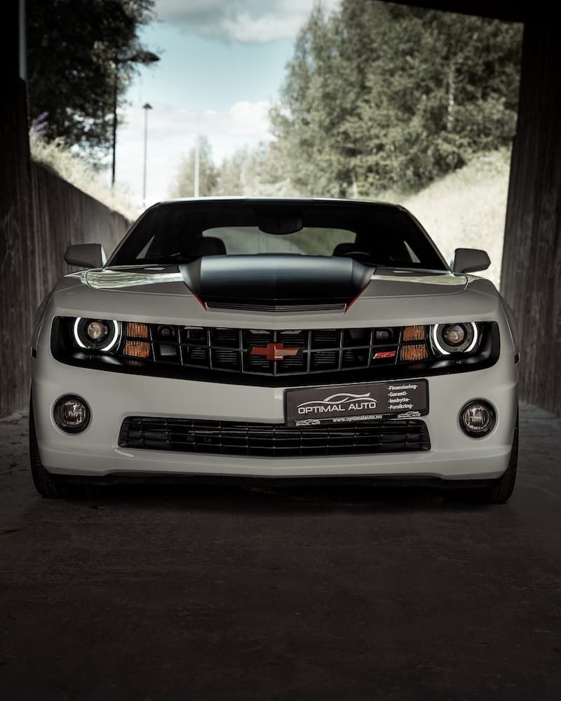 Hvit Chevrolet Camaro med Optimal Auto-skilt fotografert forfra