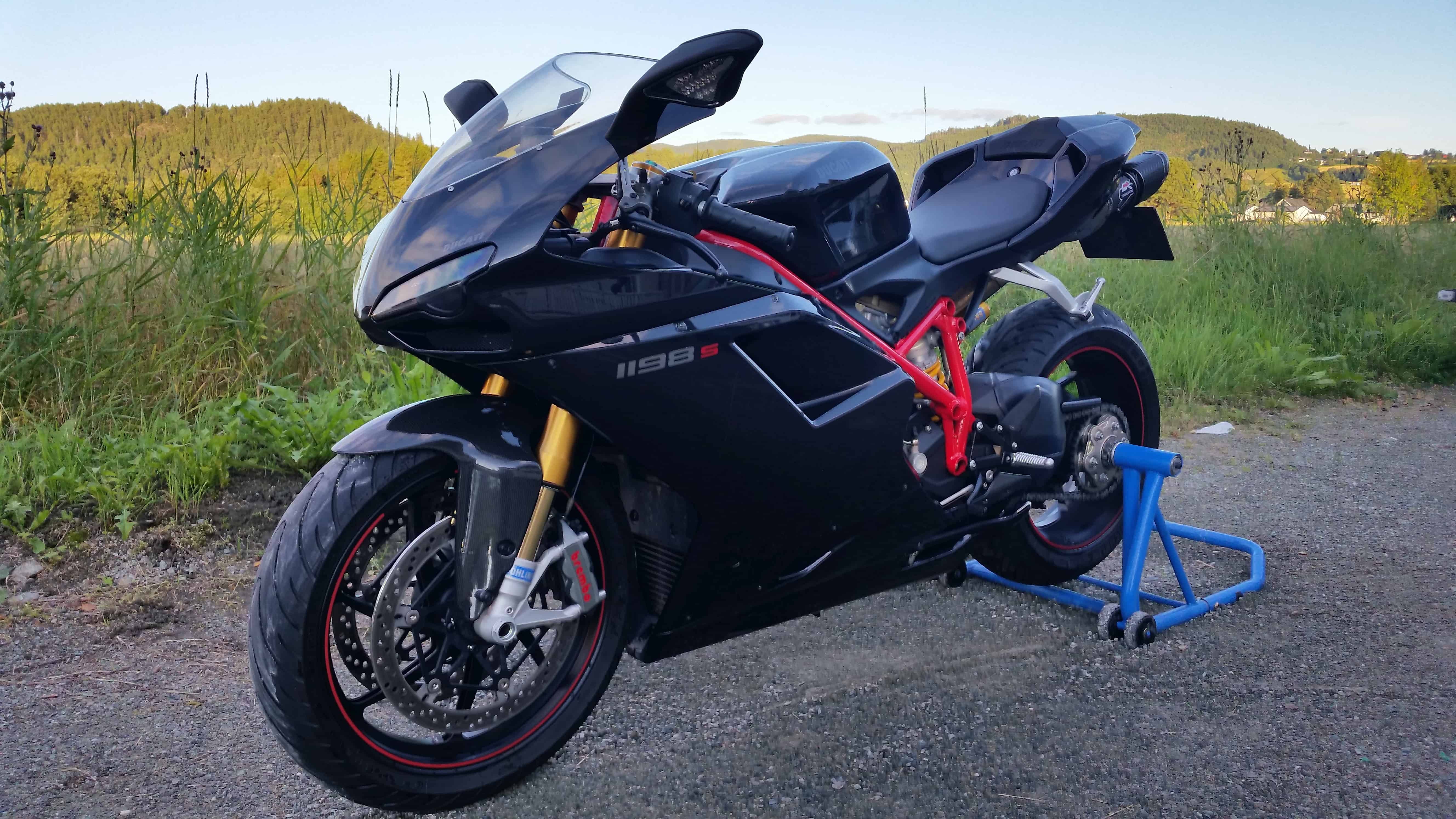 Svart Ducati superbike parkert på asfalt