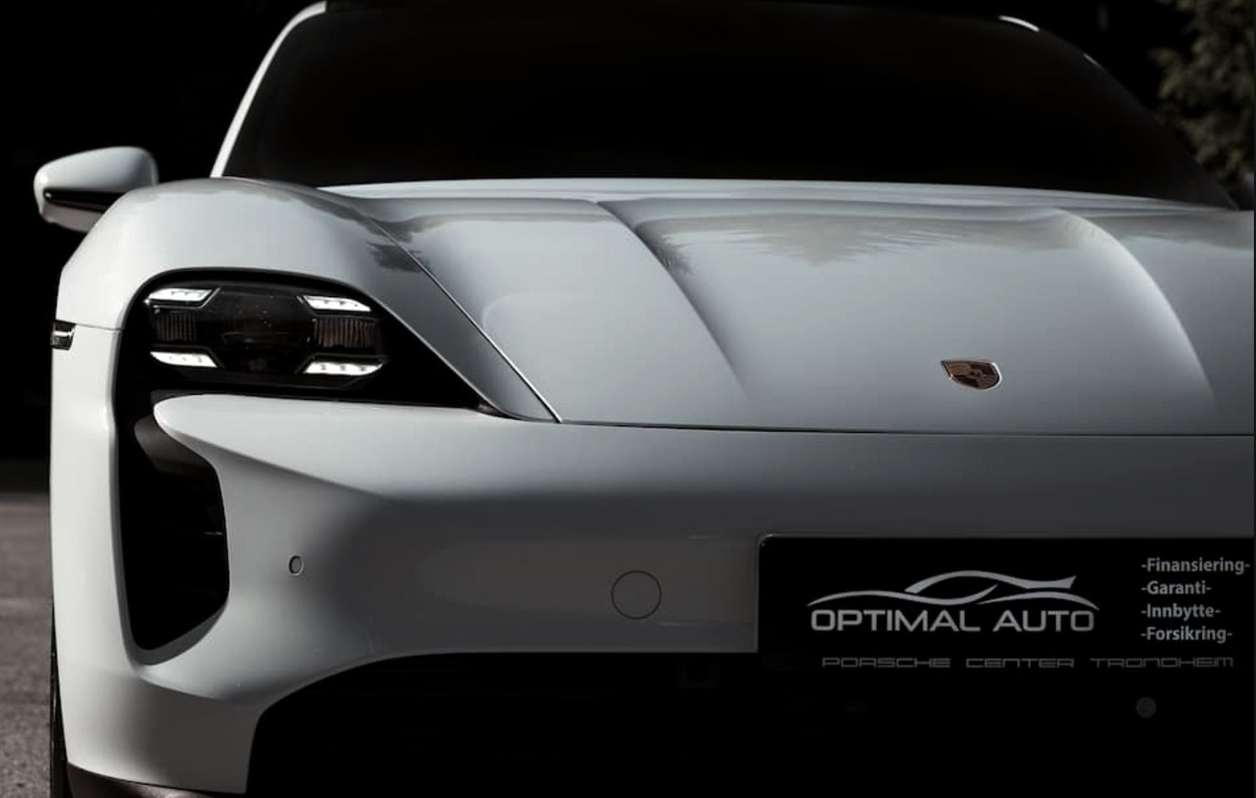 Hvit Porsche Taycan forfra med Optimal Auto-skilt